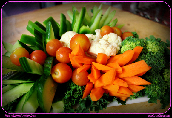 A veggie platter featuring cherry tomatoes, carrots and cucumber